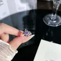 Detaillierte Nahaufnahme eines silbernen Rings mit violettem Sternkristall an der Hand - Lila Stern Hauptstein Stil (2)