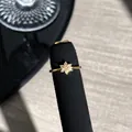 Detailansicht eines eleganten goldenen Blumenrings mit rosa Kristallen auf Ständer - Blumen Hohlstil (1)