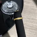 Makrodetail eines französisch vergoldeten Spitzenrings mit funkelndem Schleifendesign - Schleife Geometrischer Stil (3)