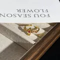 Detailed view of a retro gold flower ring with red gemstones on a display tray - No. 3 Red Gem Flower Style / Adjustable Open