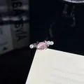 Nahaufnahme eines eleganten silbernen Rings mit rosa Katzenstein und Perlen. - Rosa Katze Perle Stil (1)