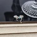 Detailansicht eines silbernen Schleifenrings mit blauem Stern und Edelsteinen. - Sternblauer Zirkon Schleife Stil (Stil 12) / Silber