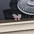 Makroansicht eines eleganten silbernen Schleifenrings mit rosa Kristallen auf Schmuck. - Rosa Baguette Zirkon Schleife Stil (Stil 13) / Silber