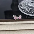 Detailansicht eines rosa schleifenförmigen Rings mit Zirkonsteinen und verstellbarem Band - Rosa Geometrischer Zirkon Schleife Stil (Stil 15) / Silber