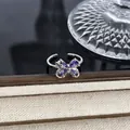 Detailansicht eines silbernen Schmetterlingsrings mit lila Kristallen in edler Umgebung. - Violetter Birnen-Zirkon-Schleife-Stil (Stil 19) / Silber