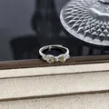 Nahaufnahme eines silbernen Schleifenrings mit funkelnden grünen Edelsteinen - Birnen-Grün-Zirkon-Schleife-Stil (Stil 22) / Silber