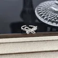 Silberner Schleifenring mit funkelnden Zirkonia auf einem beigen strukturierten Display - Funkelnder Voll-Diamant-Schleifenstil (Stil 5) / Silber
