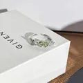 Nahaufnahme eines eleganten Silberrings mit herzförmigen grünen Edelsteinen und Perlen - Verstellbarer Ring Stil 5