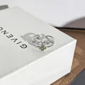 Detailaufnahme eines silbernen Schleifenrings mit einem leuchtend grünen Kristallzentrum - Verstellbarer Ring Stil 7