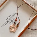 Detailed view of bohemian woven flower necklace with wooden beads and acorn charm - Woven Flower Acorn Style (X2280D)