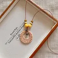 Detailed view of bohemian woven rattan pendant necklace with vintage wooden beads - Woven Round Ring Pine Cone Style (X2280A)