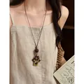 Elegant vintage long brown geometric pendant necklace on model with cream linen dress - Geometric Square Style (X2281C)