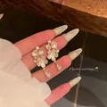 Close-up detail of elegant white flower tassel earrings with zircon crystal accents - Five-Petal Flower Artificial Pearl Rhinestone Tassel Style (E6907 Gold) / Gold