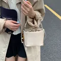 Elegante Retro-Eimertasche für Damen aus cremefarbenem Geflecht mit Perlenanhänger - Gebrochenes Weiß