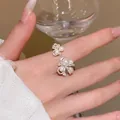 Close-up of elegant pearl and zircon open ring worn on hand holding a wine glass. - Multi-Pearl Rhinestone Open Ring (J1085) / Silver Style
