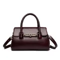 Elegant burgundy leather handbag featuring a woven top handle and gold kangaroo metal clasp - Burgundy