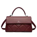 Elegant quilted burgundy leather handbag featuring a top handle and kangaroo logo. - Red