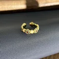 Gedetailleerde close-up van een vintage Britse emaille bloemenring met gouden finish - Verstelbare ring stijl 4