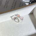 Primer plano detallado de un elegante anillo abierto plateado con tres flores rosas en 3D - Anillo Abierto Rosa Estilo 2 (439890688)
