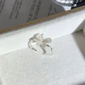 Vista detallada de un anillo abierto plateado con flor de mariposa rosa y borde perlado. - Anillo Abierto Rosa Estilo 7 (439890688)