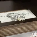 Elegante Detailansicht eines silbernen Schleifenrings mit Kristallen und Perlen - Stil Nr. 6 Offener Ring (135988825) / Silber