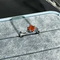 Close-up of pomegranate red gemstone ring with wavy silver band in velvet box. - Round Wave Style (17号) / Adjustable Open / Garnet Red