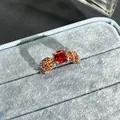 Detailed close-up of a luxury open ring featuring a vibrant garnet red center stone. - No. 35 Open Ring