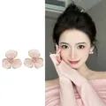 Macro view of pink three-petal flower earrings with central pink crystal on Asian model - Stud Pin Style / Pink (E6920)