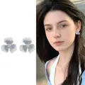Detail of elegant blue three-petal flower earrings worn by a beautiful Asian model - Stud Pin Style / Blue (E6920)