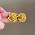 Hand-held vibrant yellow sunflower stud earrings with intricate petal details - Yellow (E6979)