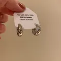 Detailed view of silver quilted texture hoop earrings on display card - Hoop Buckle Style / E6841 Silver / Silver