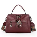 Stylish burgundy red textured faux leather Boston handbag with a patterned strap - Red