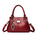 Elegant red faux leather handbag with pearl leaf charm and adjustable shoulder strap - Red