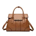 Elegant brown leather top-handle bag with kangaroo hardware and shoulder strap. - Yellow