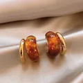 Detailed close-up showing texture of retro amber resin and gold hoop earrings on silk - Amber Double Hoop C-Shape Style (E4446) / Gold