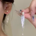 Macro detail of elegant pearl earrings featuring long silver fringe tassels on ear - Stepped Tassel Pearl Style (A1364 Silver)