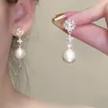 Close-up of elegant French petal pearl earrings with S925 silver needles on model ear. - Starry Petal Pearl Style (A1673 Gold)