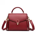 Elegant burgundy pebbled leather handbag with stylish gold-tone hardware and top handle - Red