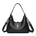 Elegant black embossed underarm bag with shoulder strap and silver turn-lock closure. - Black