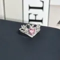 Primer plano de un anillo de cisne plateado con una piedra de circón rosa de corazón - Anillo ajustable estilo 12