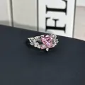 Primer plano detallado de un anillo de plata con una piedra central rosa en forma de corazón. - Anillo Abierto N.º 19