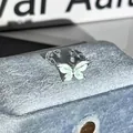 Detailansicht eines zarten mintgrünen Schmetterlingsrings auf blauem Samtstoff - Minzgrün Schmetterling Offener Ring