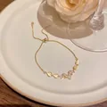 Elegant gold-tone bracelet with V-shaped zircon pendant and cat's eye heart charms - V-Shape Heart Style (S748) / Gold