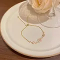 Elegant gold plated copper bracelet with zircon and cat-eye stone on white plate - Snowflake Sunflower Style (S761) / Gold