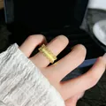 Detailansicht eines gebürsteten Goldrings mit Spitzenrand und Kristallen am Finger - Stil 2 Offener Ring (Gold)