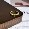 Detailansicht eines eleganten goldenen Rings mit grünen Katzenaugen und Zirkonia. - Stil 5 Offener Ring (32022154)