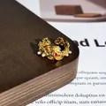 Makro-Detail eines eleganten vergoldeten Rings mit rotem Emaille-Schmetterling - Stil 11 Offener Ring (32022154)