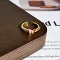 Nahaufnahme eines eleganten vergoldeten Rings mit einem rosa emaillierten Schmetterling - Stil 12 Offener Ring (32022154)