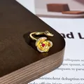 Detaillierte Makroansicht des gebürsteten Goldrosenrings mit funkelndem roten Edelstein - Stil 15 Offener Ring (32022154)