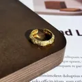 Makro-Detail eines vergoldeten offenen Rings mit kunstvoller Kristall-Pavé-Textur - Stil 18 Offener Ring (32022154)